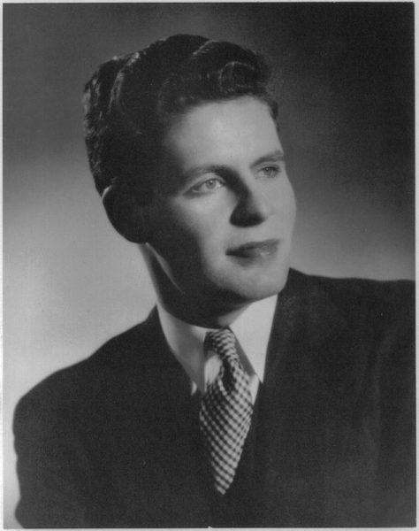 Black and white photo of a man in a suit, looking to the side.