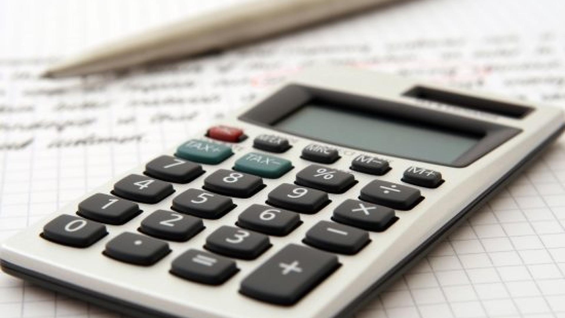Calculator and pen on graph paper with math notes.