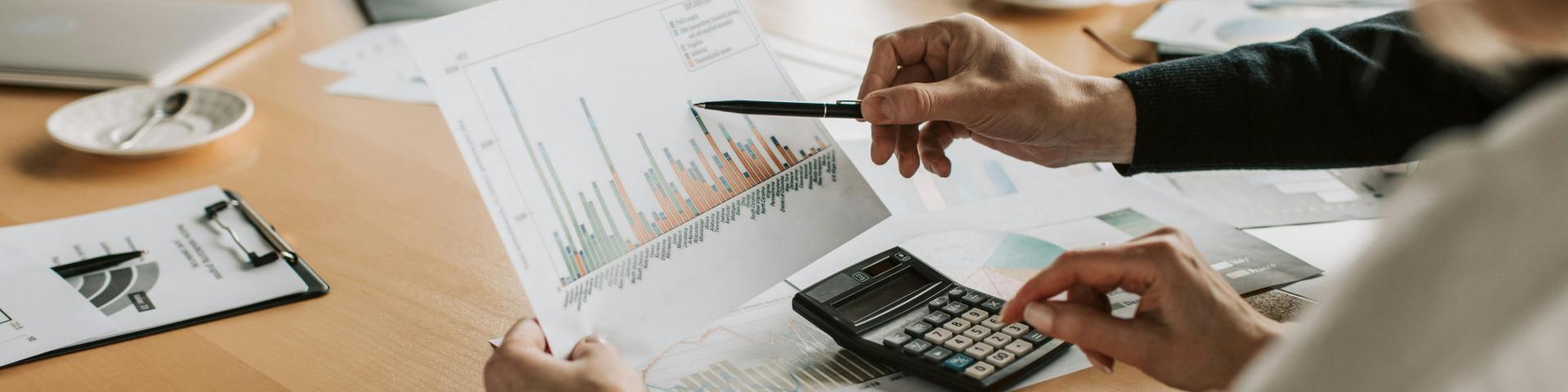 close up of a financial bar graph being held by a women at a board meeting