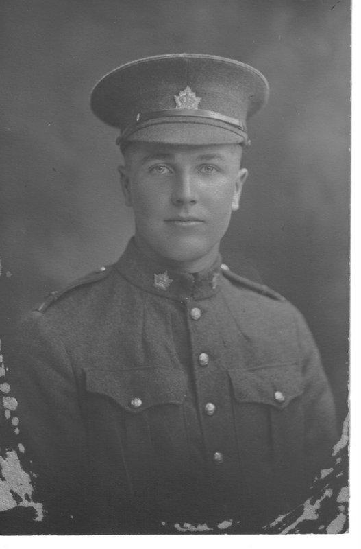 Black and white photo of a soldier in a uniform and cap.