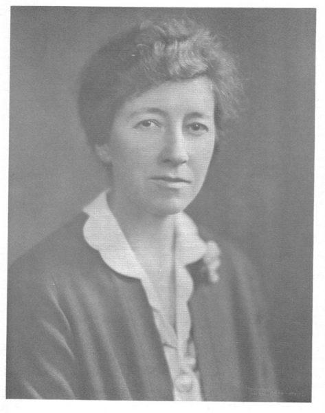 Black and white portrait of a woman with short hair, in a blouse and jacket.