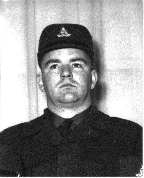 Serious man in military uniform with cap, black and white photo.
