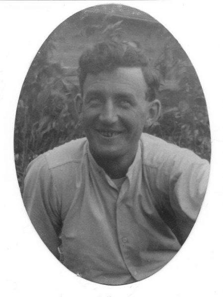 Smiling man in a vintage black-and-white portrait.