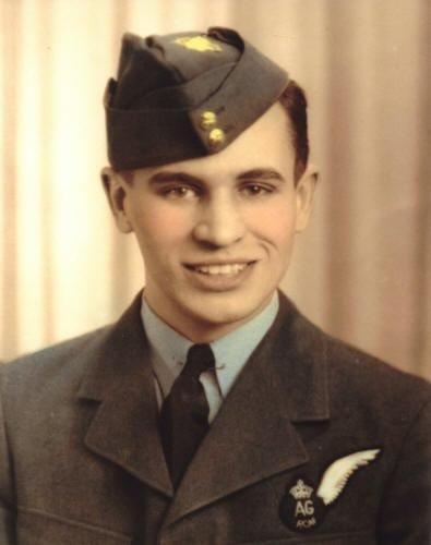 Young man in military uniform with a service cap, smiling.
