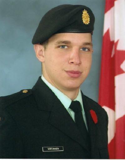 Young soldier in uniform with a beret, standing in front of a Canadian flag.