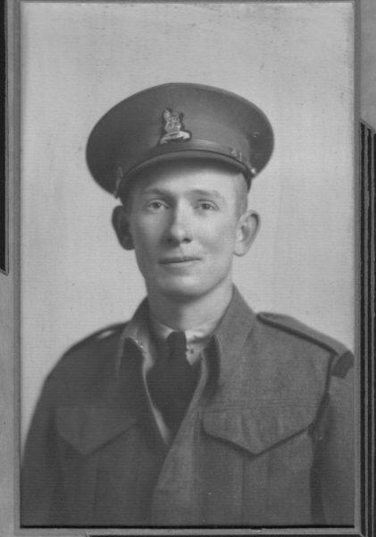 Black and white photo of a man in military uniform and cap.