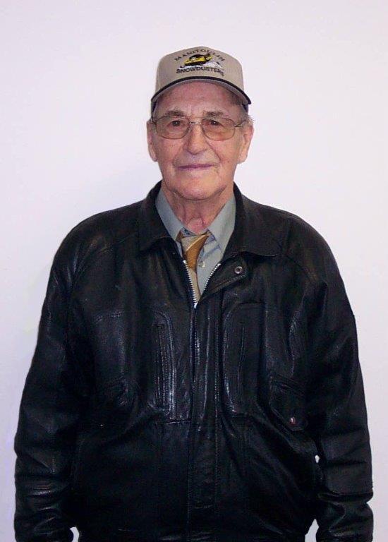 Elderly man in a leather jacket and cap, smiling.