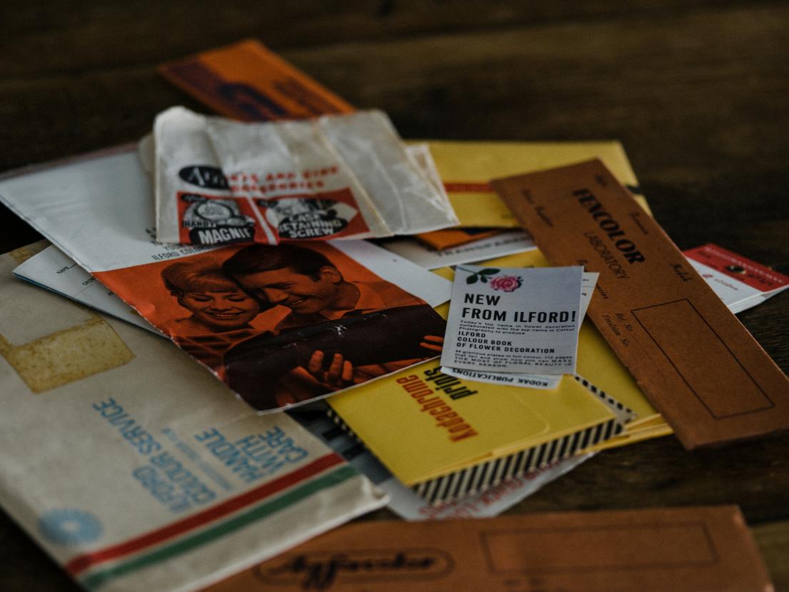 Assorted envelopes and papers scattered on a wooden surface.