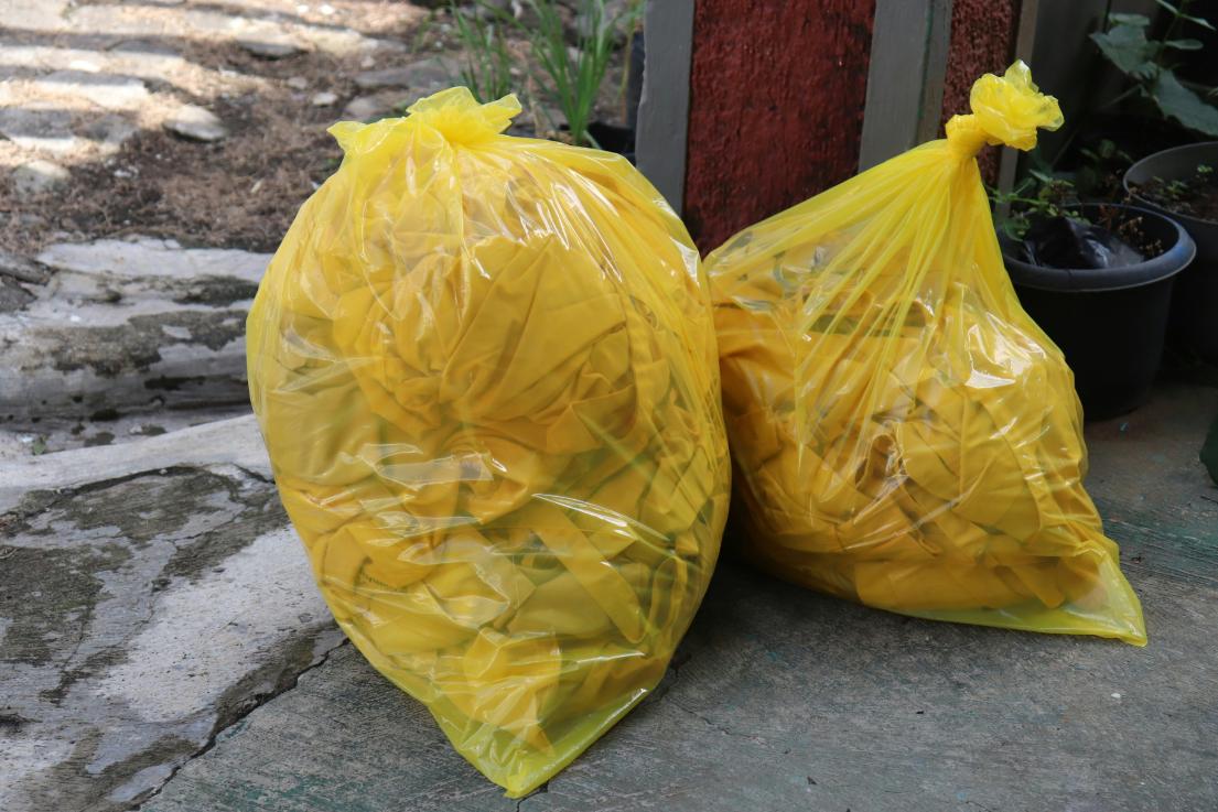 Yellow trash bags on a concrete path.