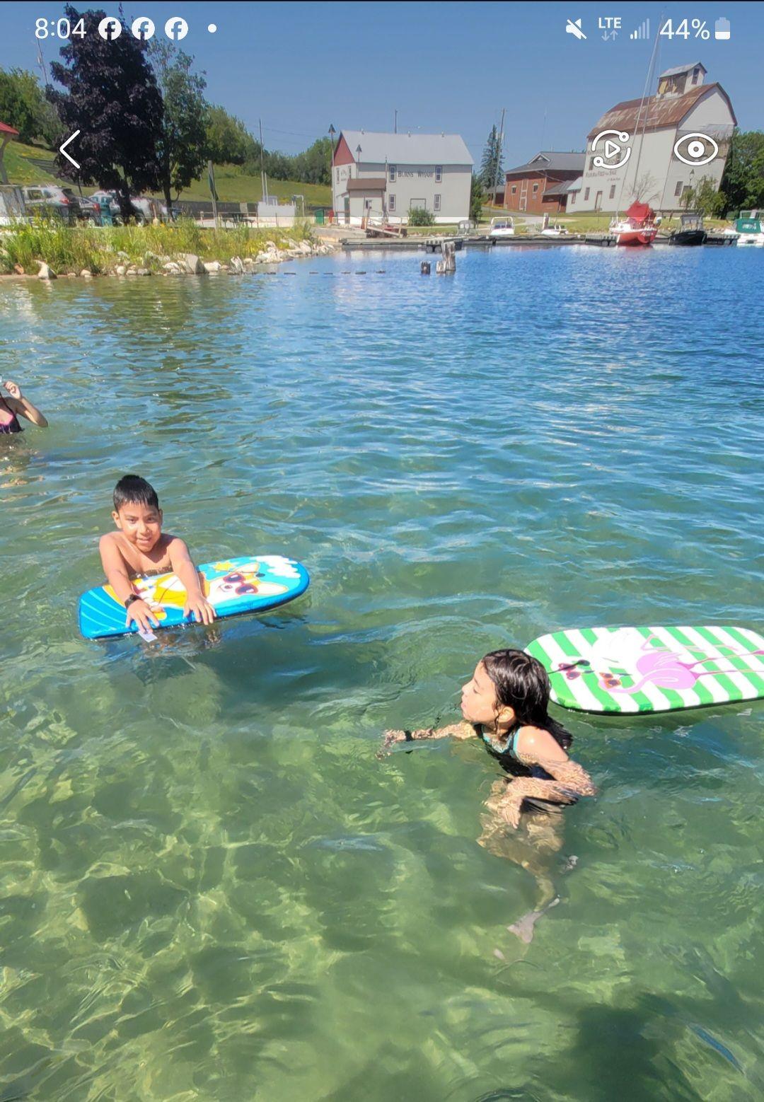 kids in the water swimming with floatboards